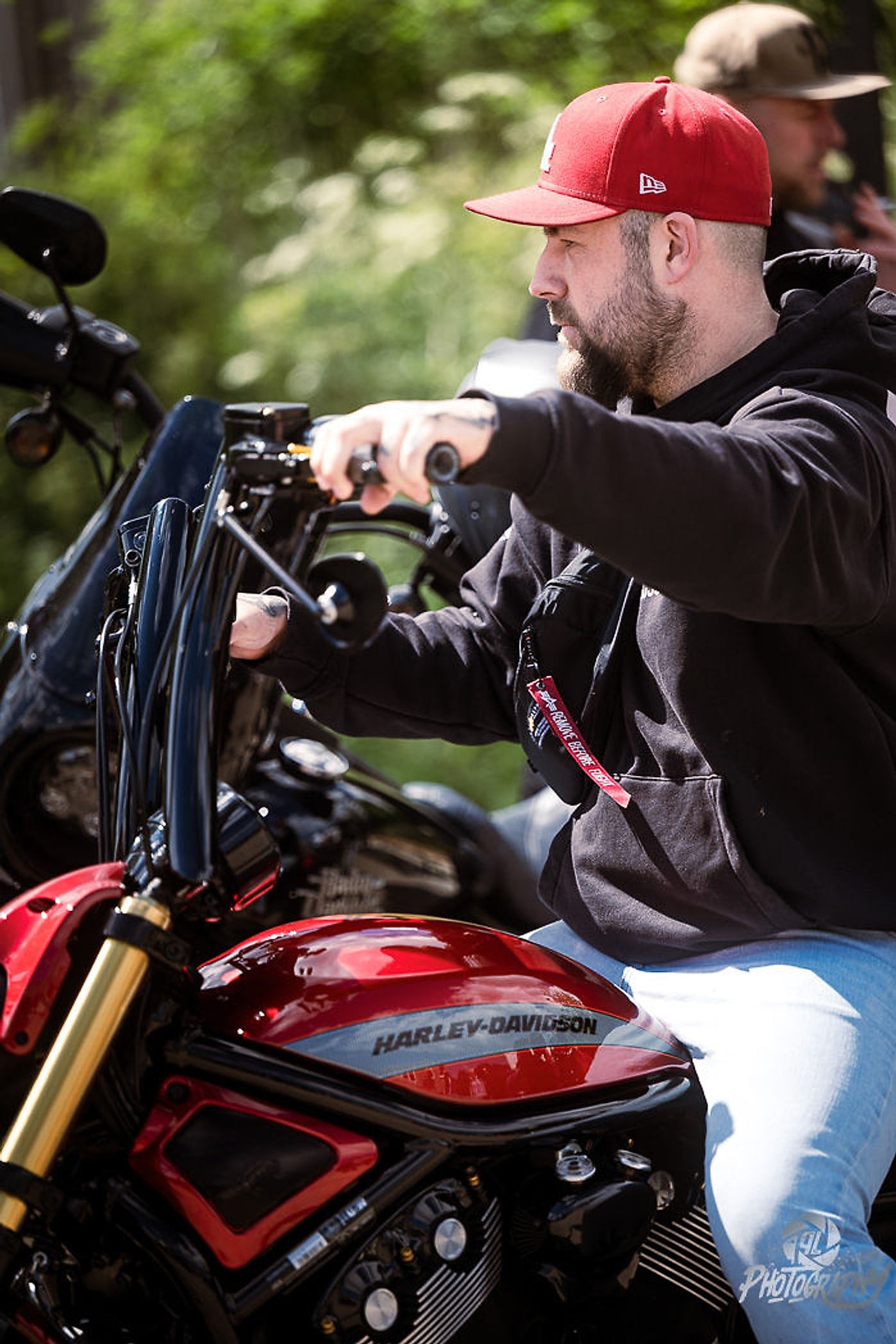 Biker mit roter Cap sitzt auf seiner roten Harley