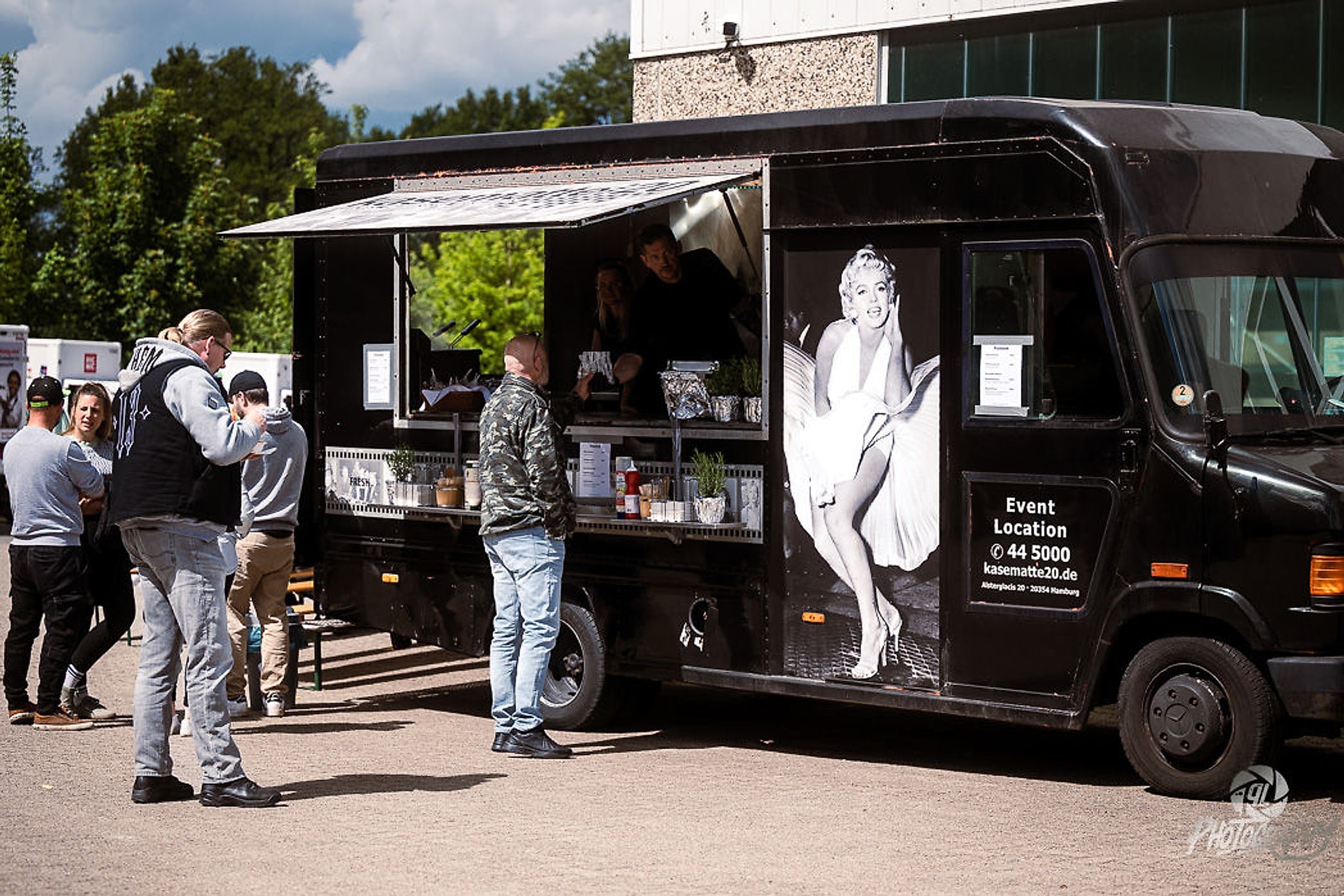 Schwarzer Food Truck mit Marilyn-Monroe-Motiv, davor Besucher in der Schlange