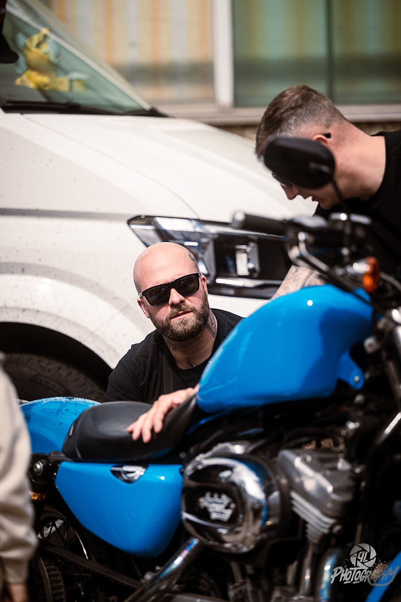 Fahrzeugaufbereitung live: Mann poliert den blauen Tank einer Sportster